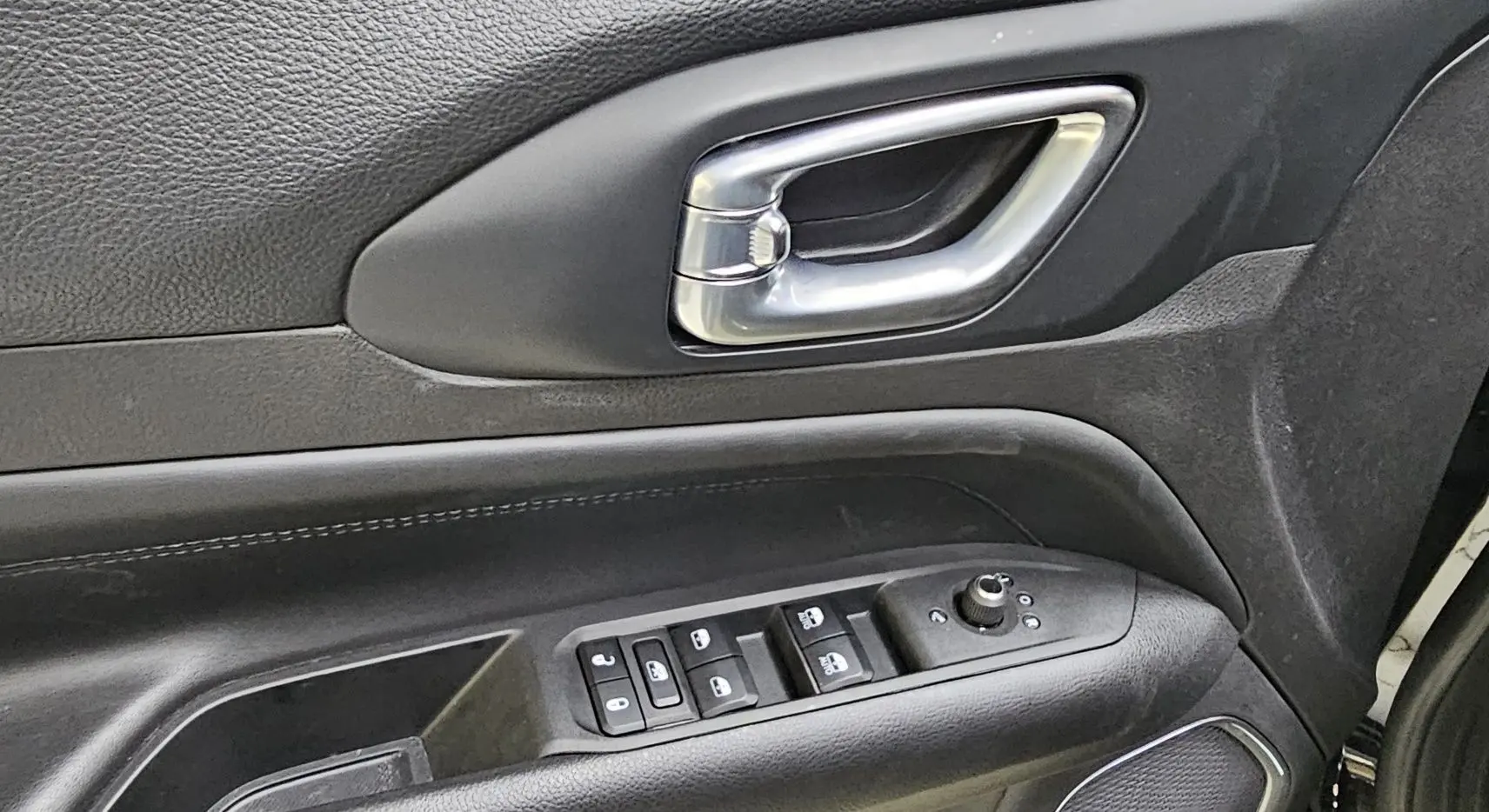 Poignée de porte intérieure côté gauche noire avec commandes électriques sur Jeep Compass 2023 hybride essence.