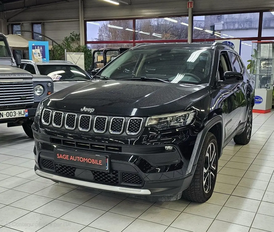 Jeep Compass noir en 3/4 avant droit dans un showroom, avec calandre distinctive à sept fentes et jantes alliage.