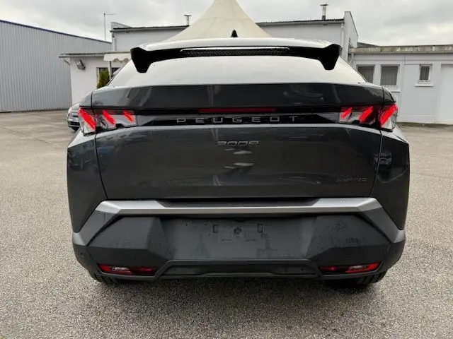 Vue arrière d'un Peugeot 3008 Hybrid 145 GT gris titane avec feux arrière LED en forme de griffes et toit noir.