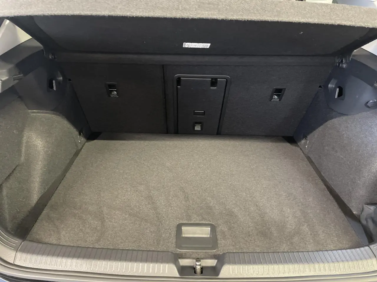 Coffre ouvert de la Volkswagen Golf 1.5 eTSI Style 2024 noir, montrant l'espace de chargement et la banquette arrière rabattable.