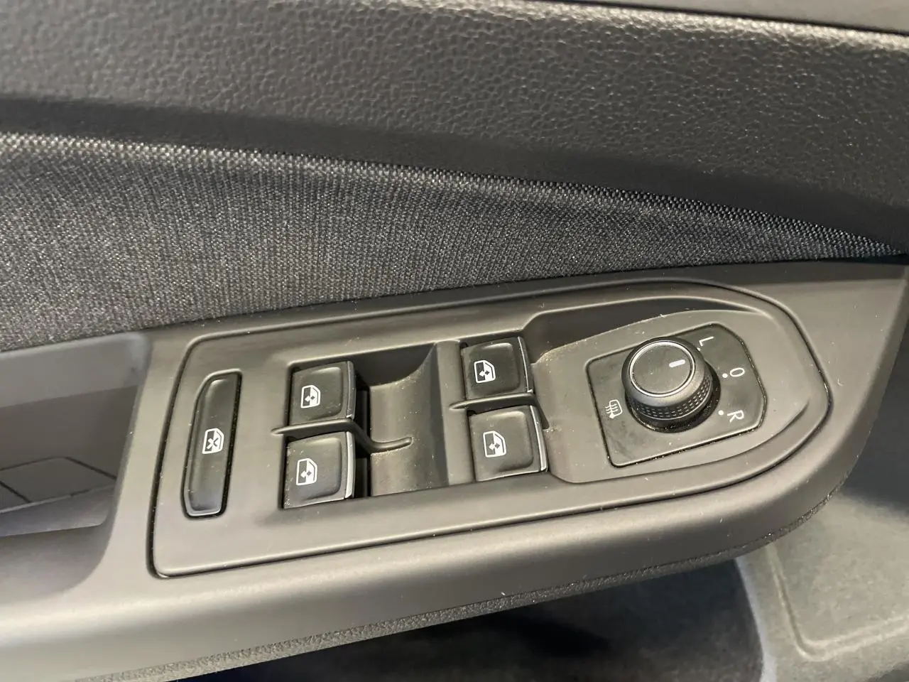Commande des vitres électriques et réglage des rétroviseurs côté conducteur de la Volkswagen Golf noire 2024 Style.