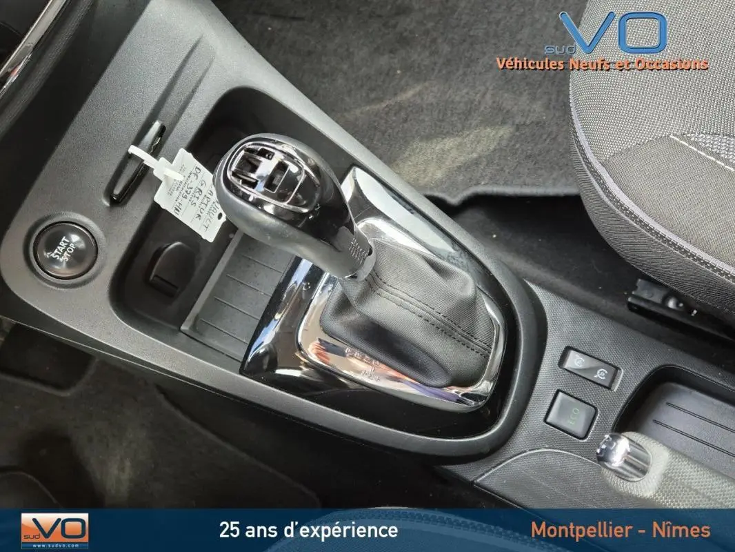 Gros plan sur la console centrale du Renault Captur gris 2014, mettant en valeur la boîte automatique et le bouton start/stop.