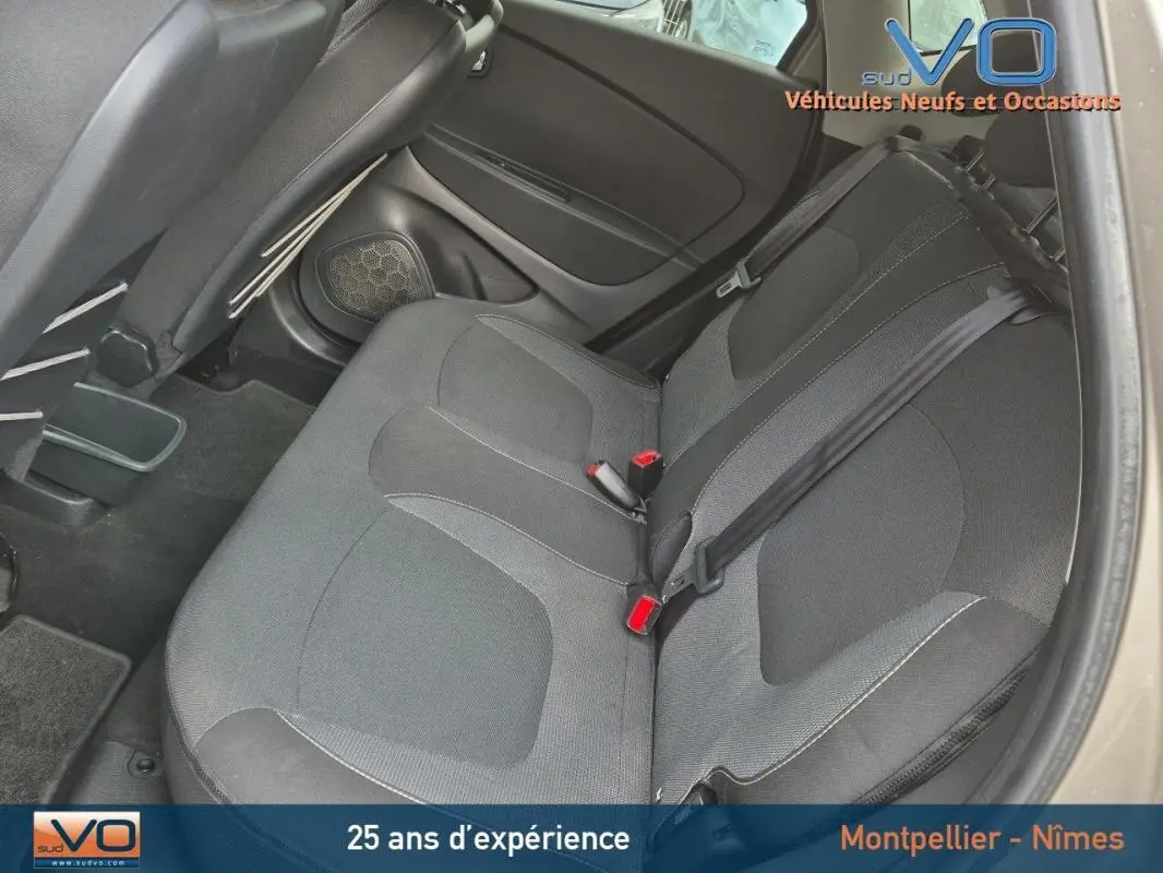 Vue intérieure sur les sièges arrière noirs du Renault Captur gris, avec ceintures de sécurité et appuis-tête visibles.