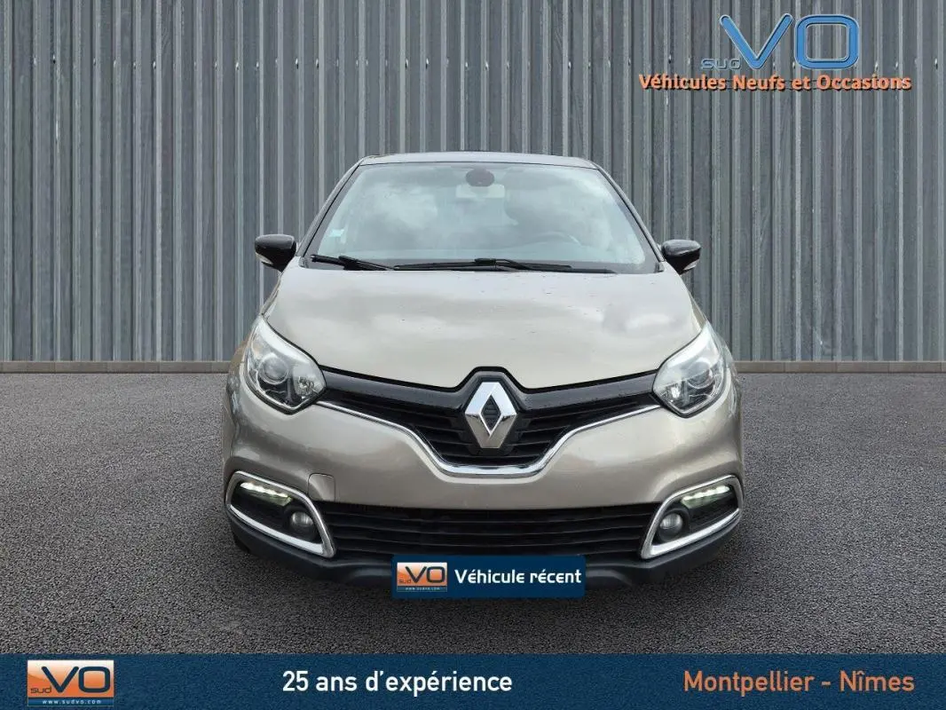 Vue frontale d'un Renault Captur gris 2014 avec feux diurnes LED et calandre noire distinctive.