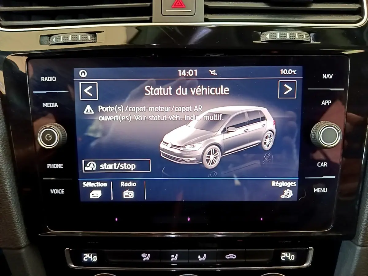 Écran tactile central affichant le statut d'une Volkswagen Golf gris clair vue de profil droit en intérieur du véhicule.