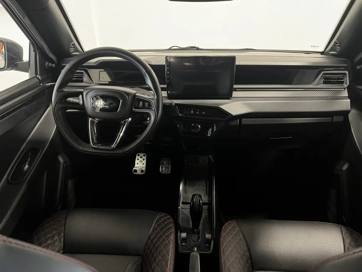 Vue intérieure frontale du tableau de bord noir de la LIGIER JS50 0.5 REVO D+ ULTIMATE avec écran tactile central.
