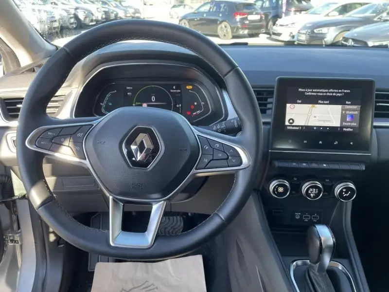 Vue intérieure du volant et tableau de bord du Renault Captur gris métal 2022, avec écran tactile et commandes au volant.