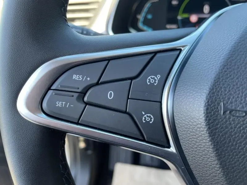 Gros plan sur les commandes de régulateur de vitesse au volant d'un Renault Captur gris métal 2022 hybride.