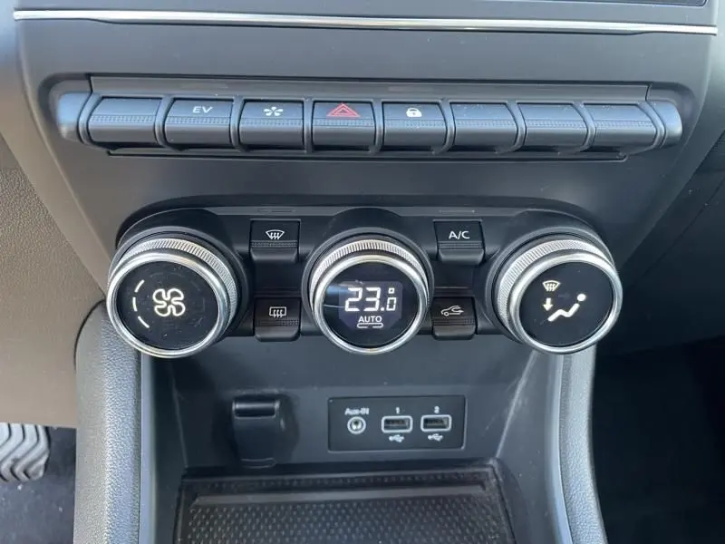 Gros plan sur les commandes de climatisation du Renault Captur gris métal 2022, affichant 23°C en mode automatique.