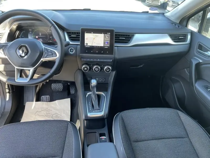 Vue intérieure avant du Renault Captur gris métal 2022, avec tableau de bord numérique et écran tactile central.