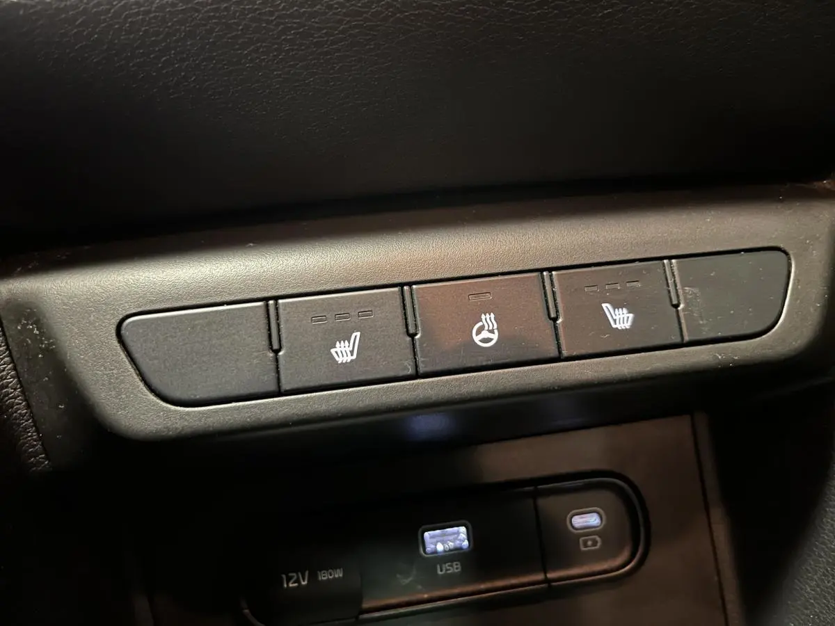 Boutons de chauffage des sièges et du volant sur la console centrale du Kia Sportage marron 2022.
