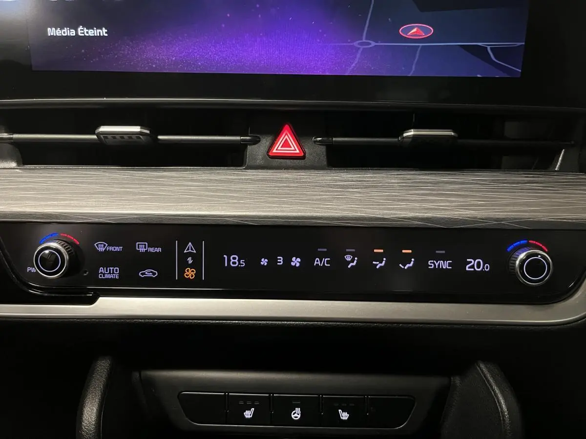 Tableau de bord du Kia Sportage 2022 montrant la commande de climatisation automatique avec affichage digital et réglages rotatifs.