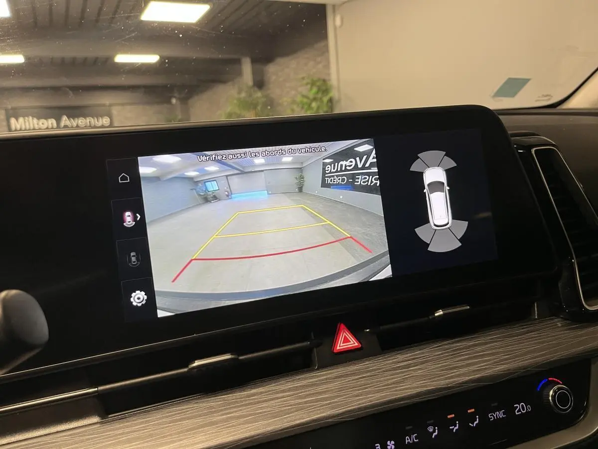 Écran tactile intérieur du Kia Sportage 2022 montrant la caméra de recul avec lignes de guidage en garage.