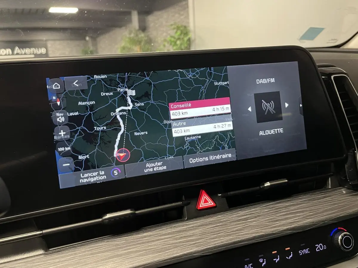 Vue rapprochée de l'écran tactile central du Kia Sportage 2022 montrant la navigation et la radio DAB/FM