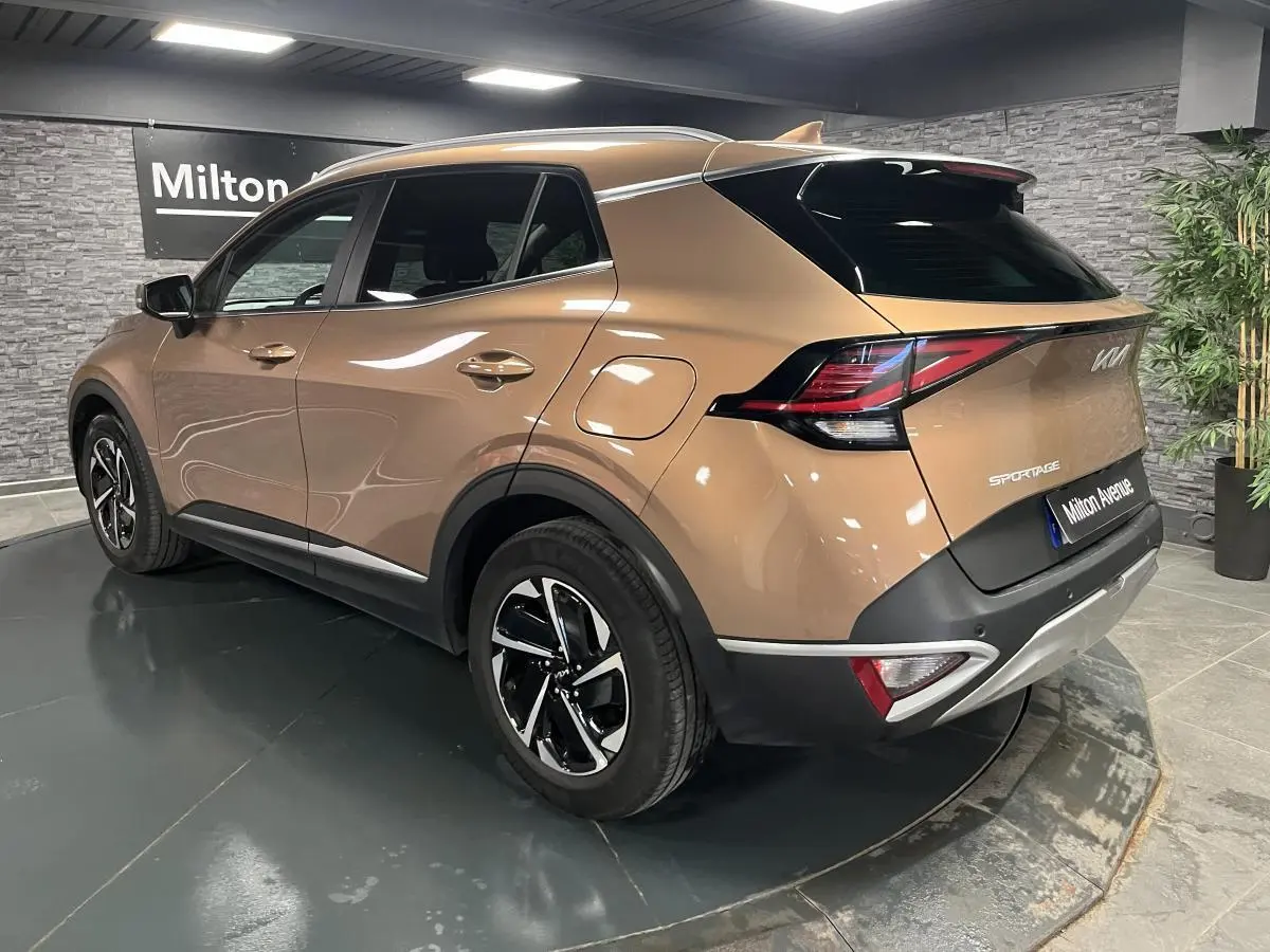 Vue 3/4 arrière droit d'un KIA SPORTAGE marron métallisé avec jantes alliage 17 pouces et feux arrière LED boomerang.