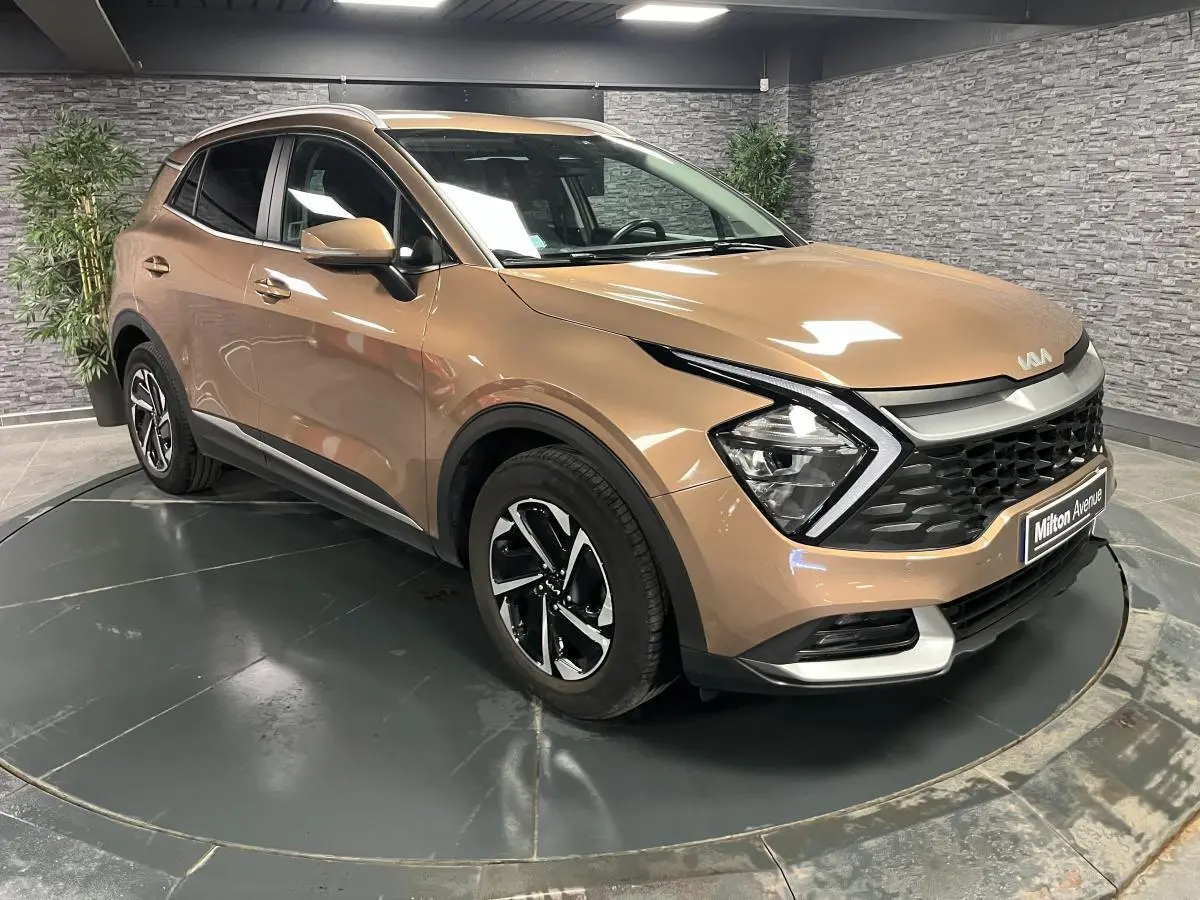 KIA SPORTAGE marron métallisé en 3/4 avant droit avec calandre noire laquée et jantes alliage 17 pouces.