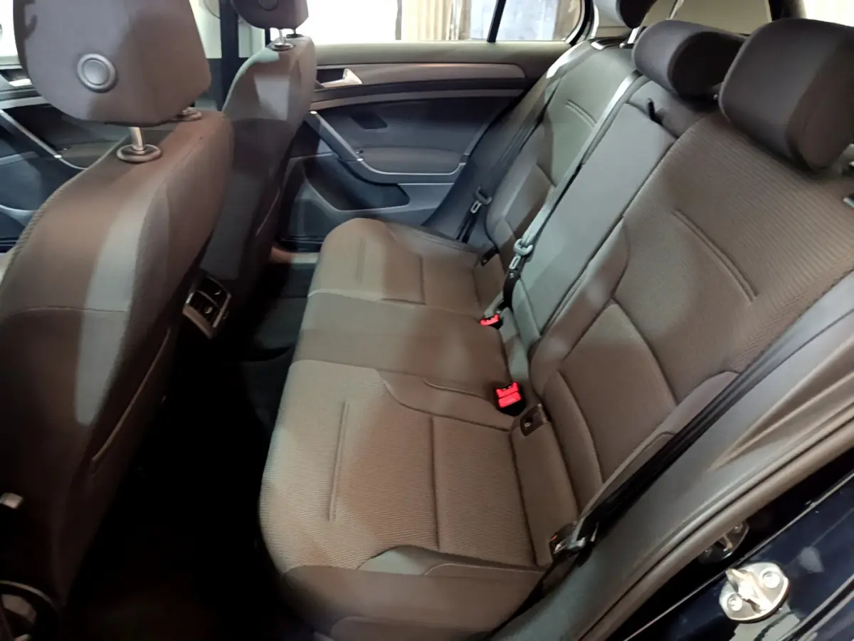 Vue intérieure côté droit sur la banquette arrière grise de la Volkswagen Golf 1.6 TDI 2018 avec appuie-têtes et ceintures visibles.