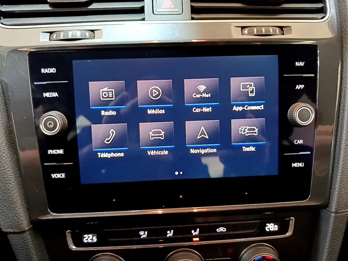 Écran tactile central affichant les options multimédia et navigation de la Volkswagen Golf noire, vue intérieure rapprochée.