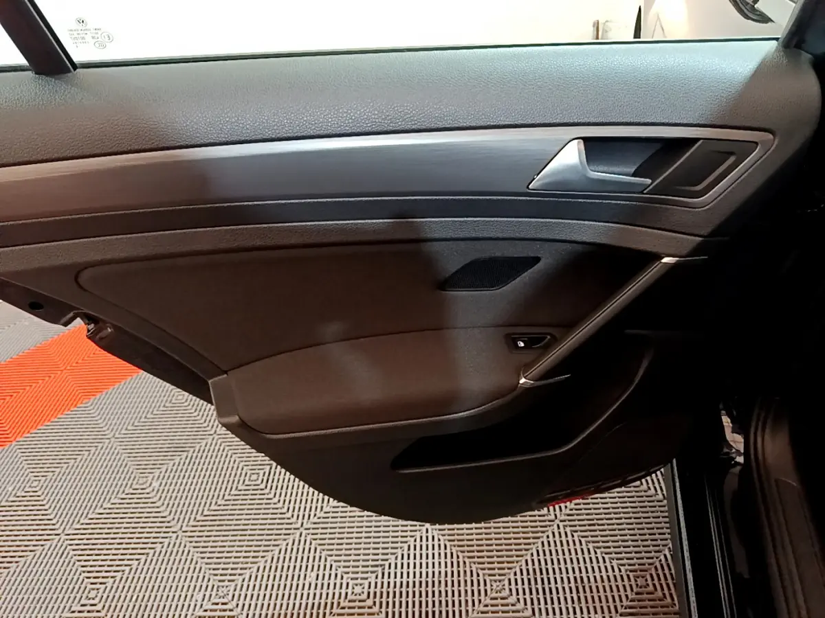 Vue intérieure du panneau de porte côté droit noir de la Volkswagen Golf 2018 avec poignée argentée et haut-parleur intégré