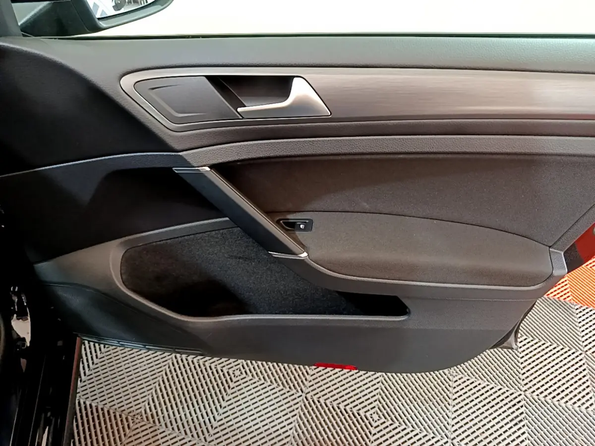 Vue rapprochée de la porte intérieure côté gauche noire de la Volkswagen Golf 1.6 TDI 2018 avec insert bois.