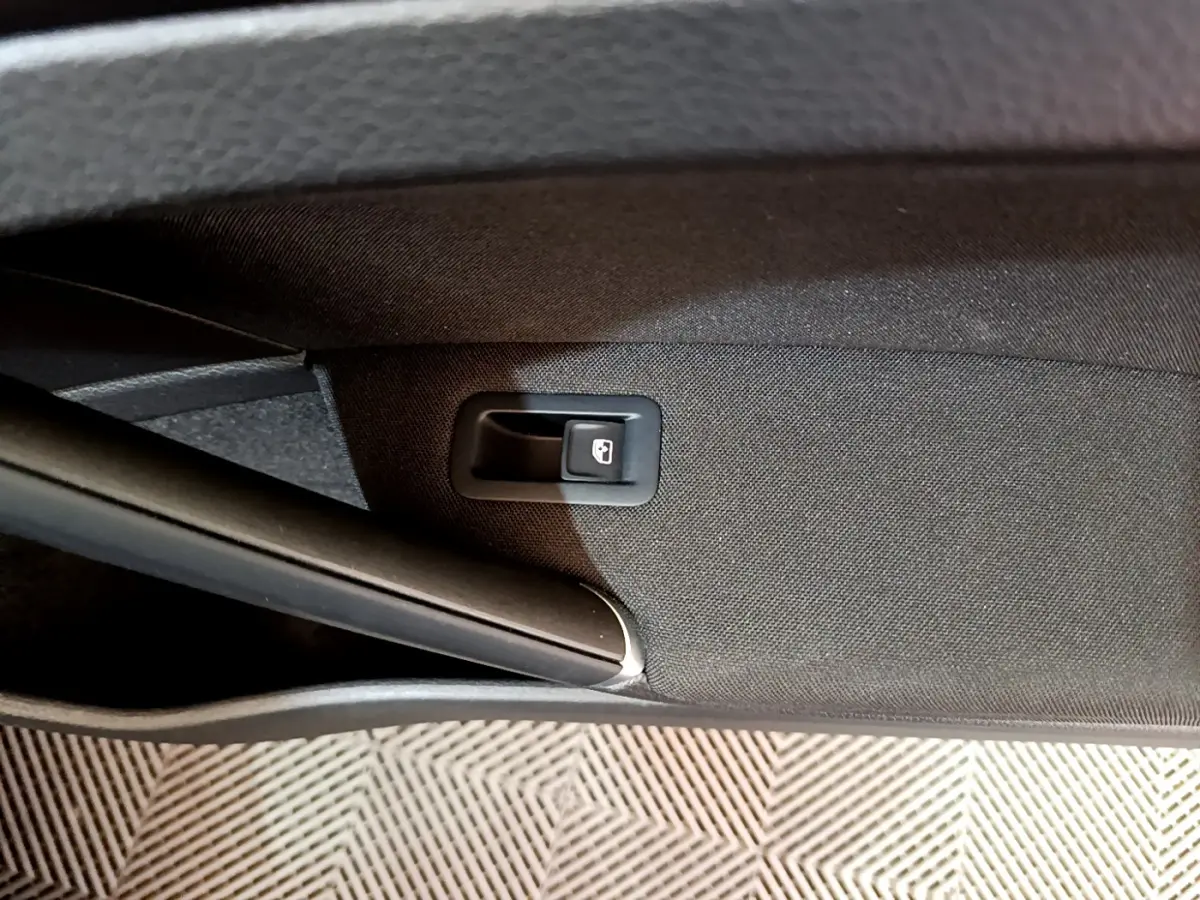 Détail de la poignée d'ouverture intérieure du coffre sur la porte arrière droite d'une Volkswagen Golf noire 2018.