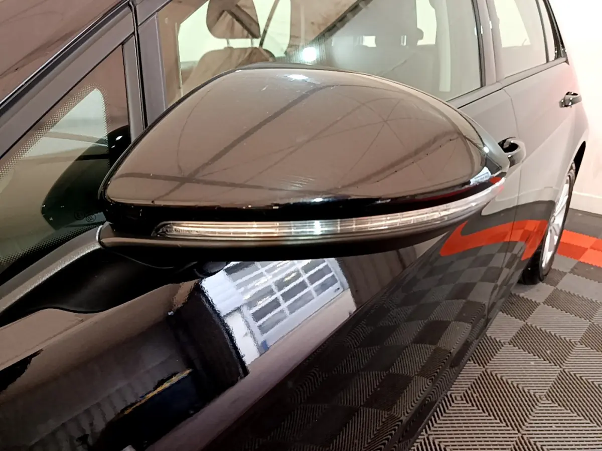 Rétroviseur droit noir brillant avec clignotant intégré sur Volkswagen Golf 1.6 TDI 2018 vue rapprochée côté passager.