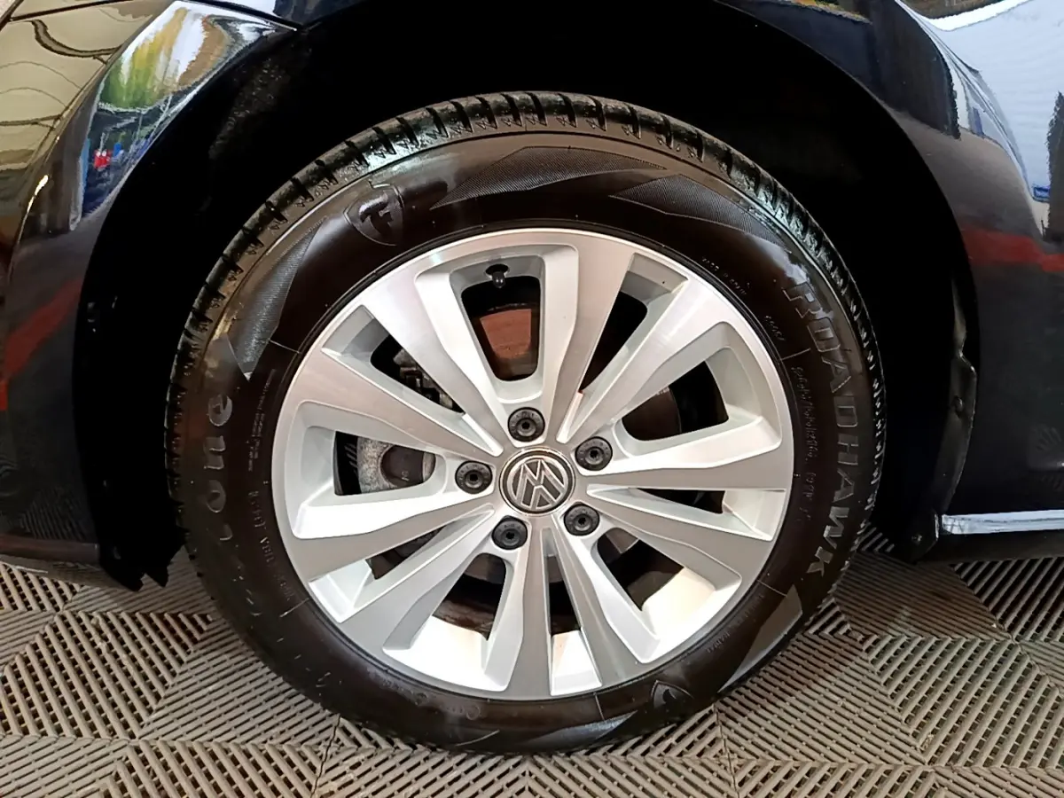 Gros plan sur la roue avant gauche d'une Volkswagen Golf noire de 2018 avec jante alliage à 10 branches.