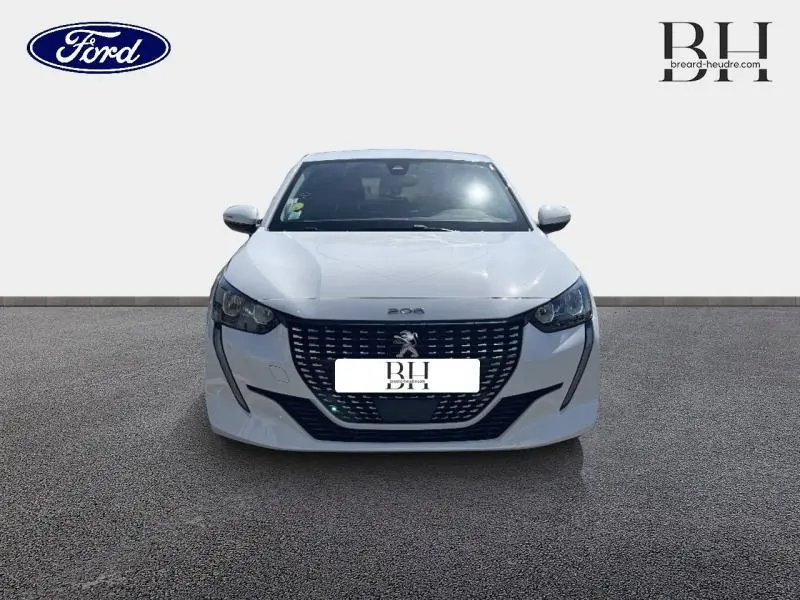 Vue frontale d'une Peugeot 208 blanche Banquise avec calandre noire et phares LED distinctifs.