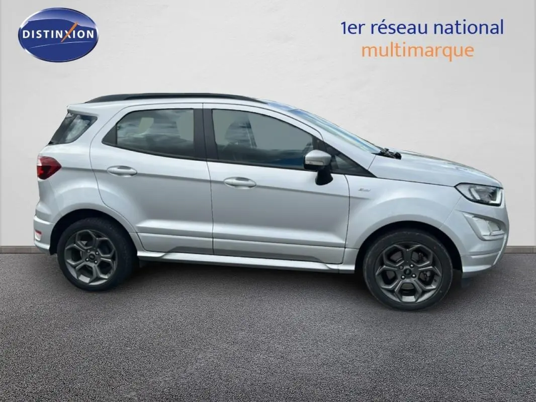 Vue de profil côté gauche d'un Ford EcoSport gris clair avec jantes alliage 17 pouces et barres de toit noires.