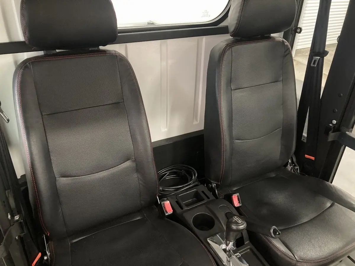 Vue intérieure rapprochée des deux sièges noirs du Liberty L7E H2 160 avec revêtement en aluminium blanc en arrière-plan.