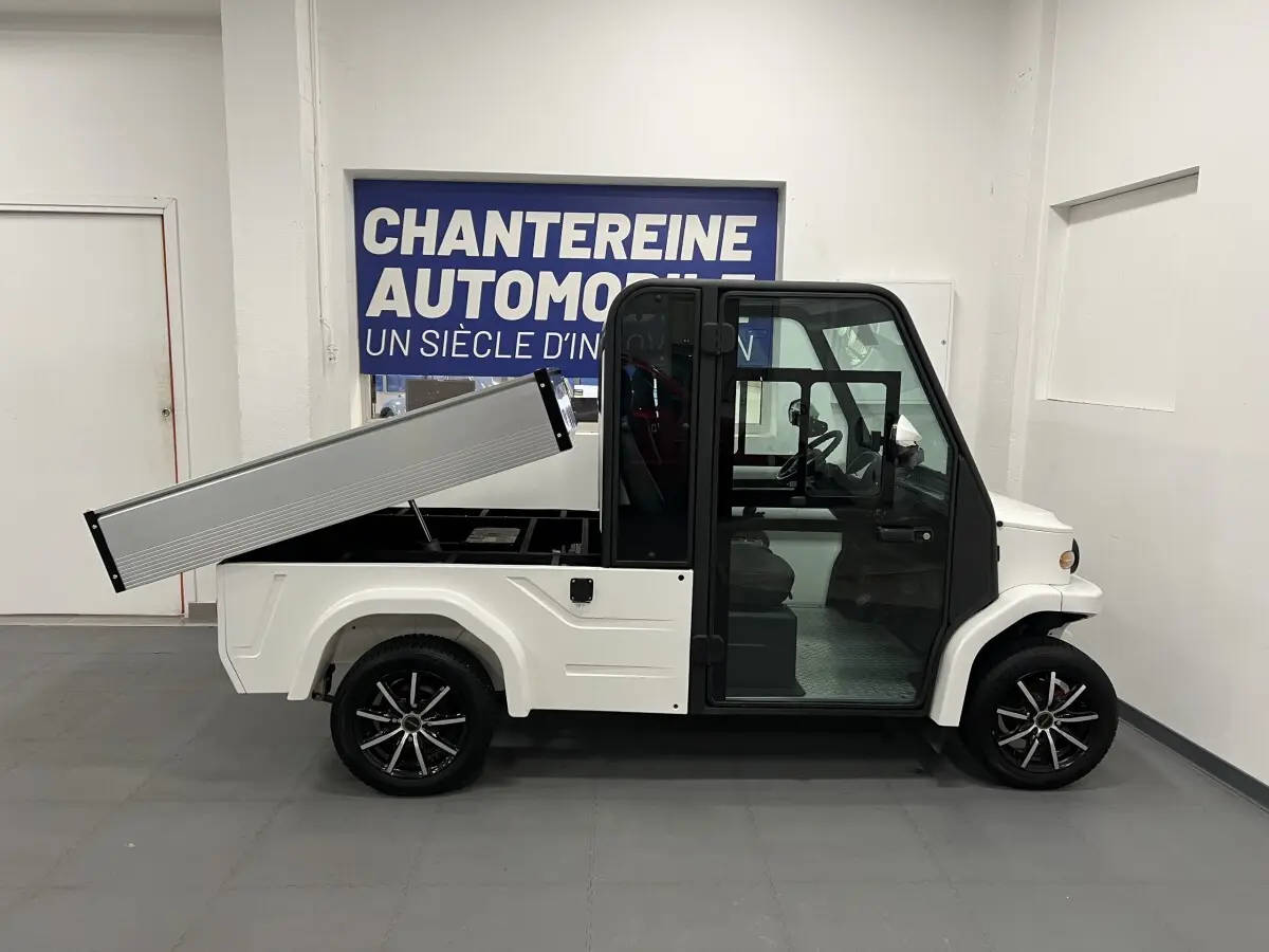 Vue de profil droit du Liberty L7E H2 160 blanc 2026 avec kit ridelles relevé et jantes alliage 13 pouces.