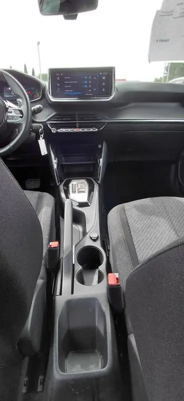 Vue intérieure centrée sur la console centrale et tableau de bord noir du Peugeot 2008 Hybrid 145 e-DCS6 Style 2025.
