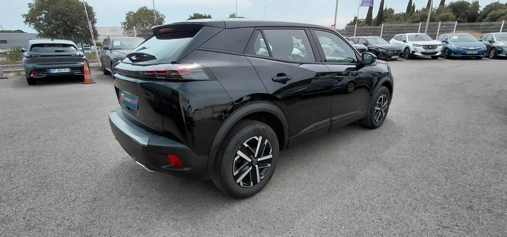 Vue 3/4 arrière droite d’un Peugeot 2008 Hybrid 145 noir 2025, soulignant ses feux arrière effilés et ses jantes modernes.