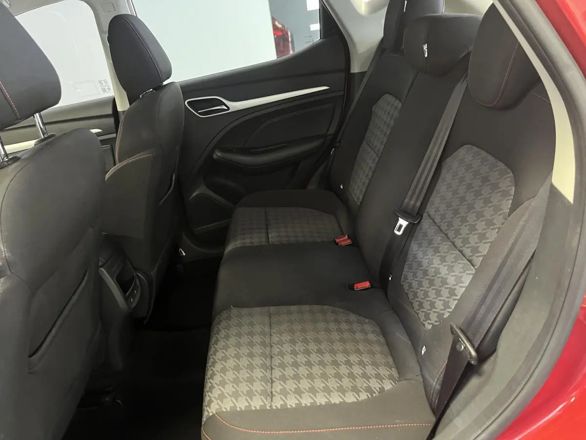 Vue intérieure côté droit sur la banquette arrière en tissu gris à motifs, avec portières rouges visibles sur MG ZS 2022.