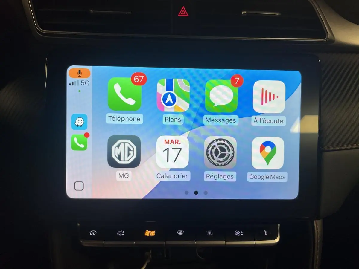 Écran tactile central de la MG ZS 2022 affichant Apple CarPlay avec icônes colorées et commandes en dessous.