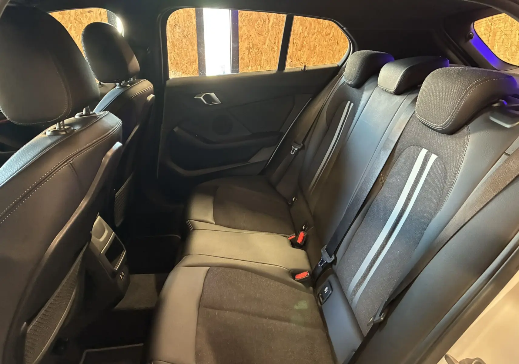 Vue intérieure côté droit des sièges arrière noirs en tissu et cuir de la BMW Série 1 118i Edition Sport 2023.