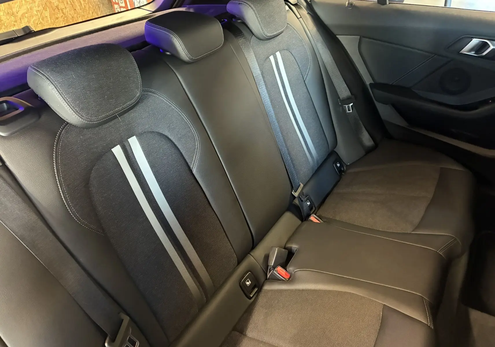 Vue intérieure du siège arrière en tissu noir avec bandes grises d'une BMW Série 1 118i Edition Sport 2023.