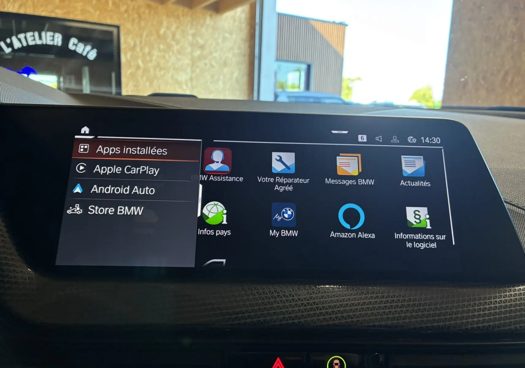 Écran tactile central de la BMW Série 1 118i Edition Sport 2023 affichant les applications connectées et options multimédia.