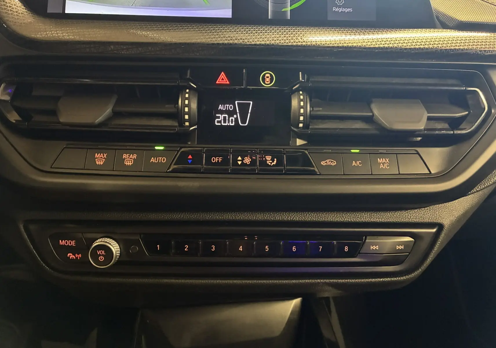 Détail du tableau de bord noir de la BMW Série 1 118i Edition Sport 2023 avec commandes climatisation et multimédia.