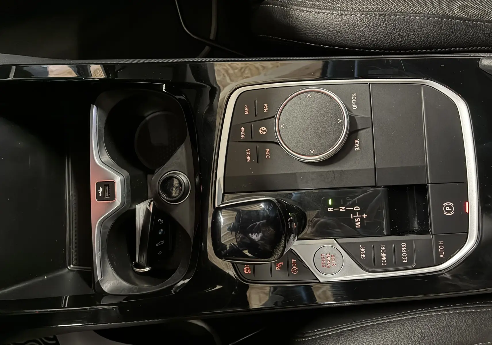 Vue rapprochée de la console centrale noire brillante de la BMW Série 1 118i Edition Sport avec levier de vitesse automatique et commandes multimédia.