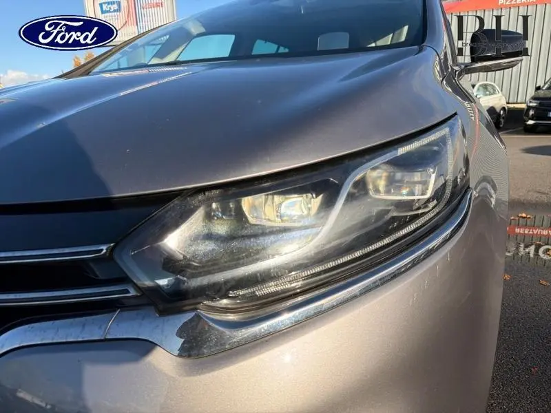 Gros plan sur le phare avant droit du Renault Espace gris Cassiopée, mettant en valeur ses lignes modernes et chromées.