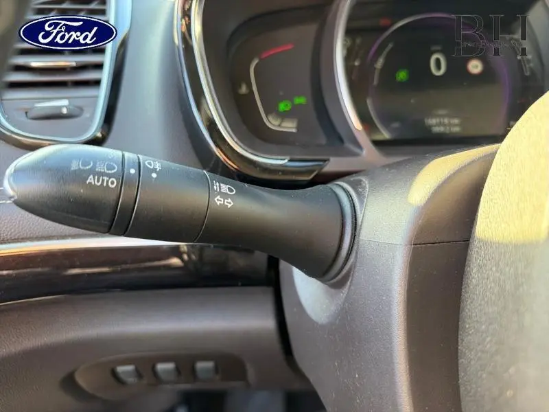 Gros plan sur la commande des feux et clignotants à gauche du volant d'un Renault Espace gris Cassiopée, tableau de bord partiellement visible.