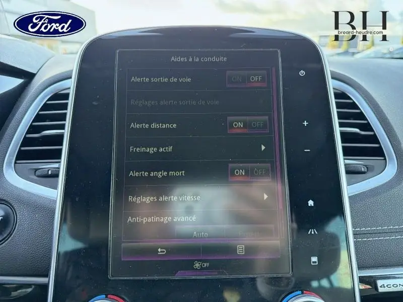 Écran tactile central du tableau de bord d'un Renault Espace gris Cassiopée, affichant les aides à la conduite.