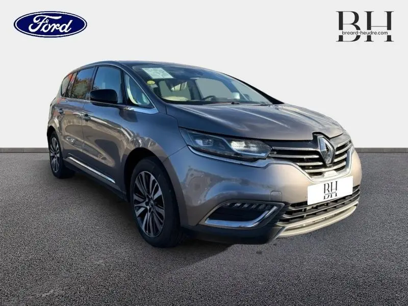 Renault Espace gris Cassiopée en 3/4 avant droit, mettant en valeur ses phares LED et sa calandre distinctive.