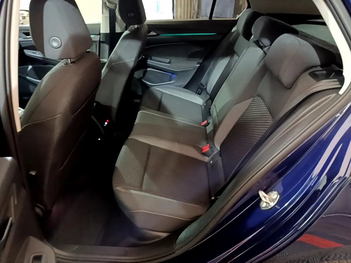 Vue côté gauche sur les sièges arrière gris foncé de la Volkswagen Golf 1.0 TSI Active bleu 2022 avec portes ouvertes.