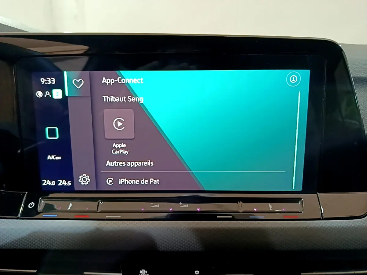 Écran tactile central affichant Apple CarPlay dans l'habitacle d'une Volkswagen Golf bleu 2022.