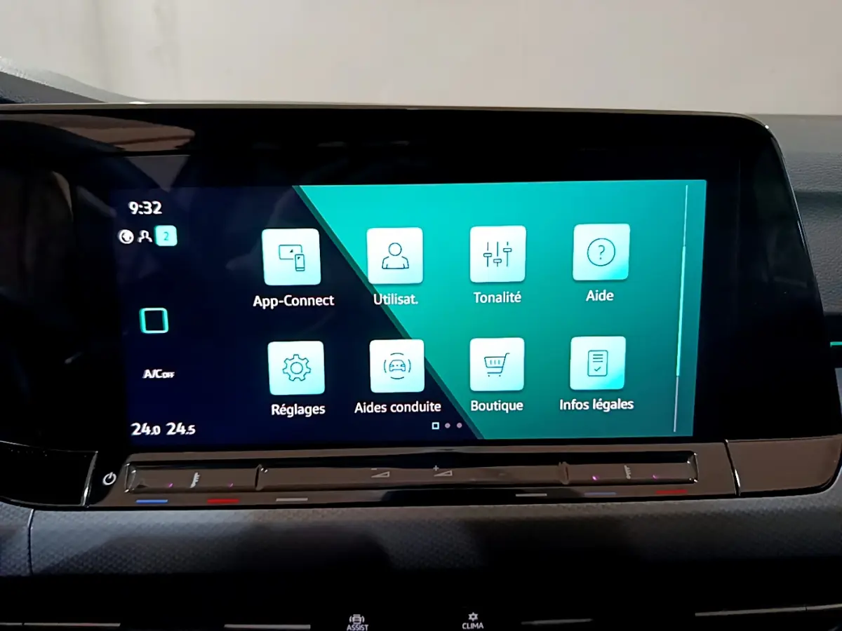 Écran tactile central du tableau de bord de la Volkswagen Golf bleu 2022 affichant les menus d'aide et réglages.