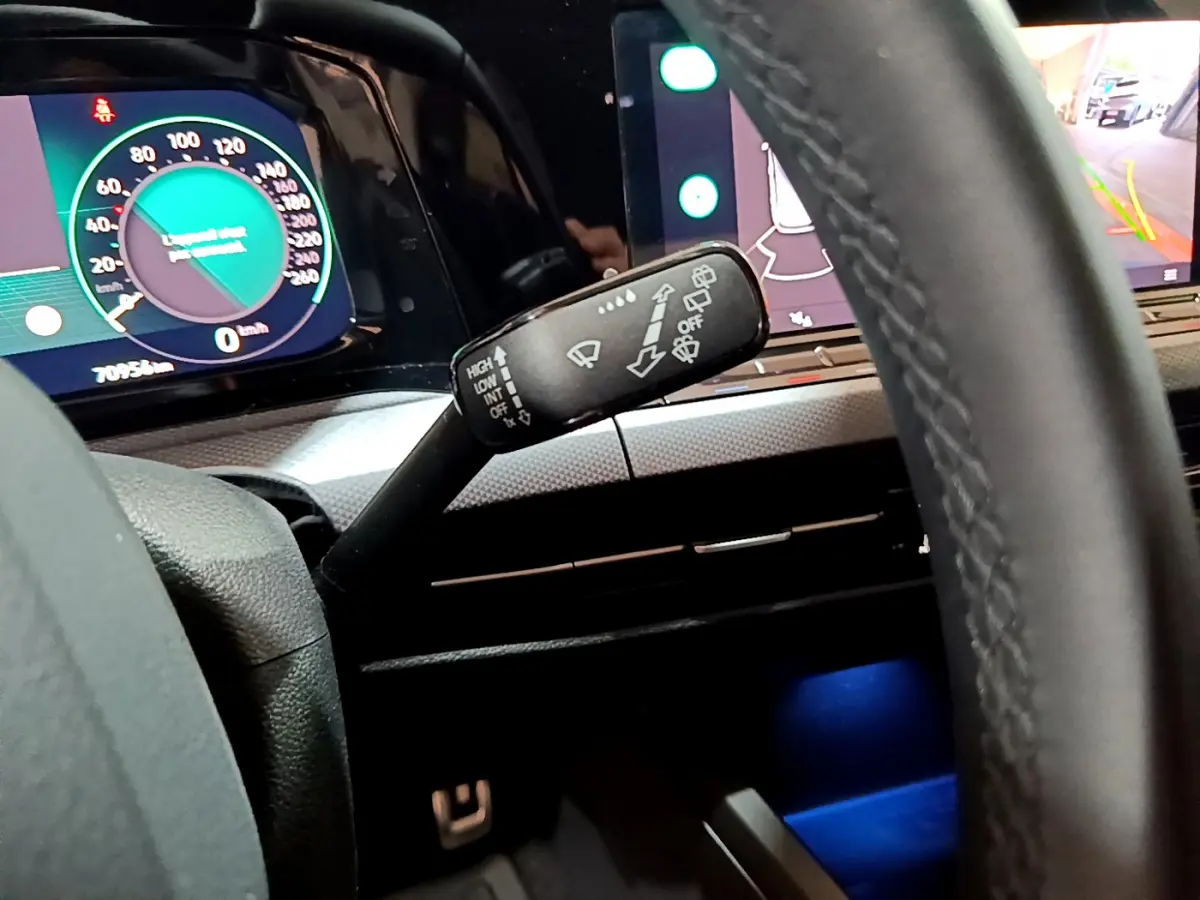 Gros plan sur la manette d'essuie-glace à gauche du volant cuir dans l'habitacle d'une Volkswagen Golf bleue 2022.