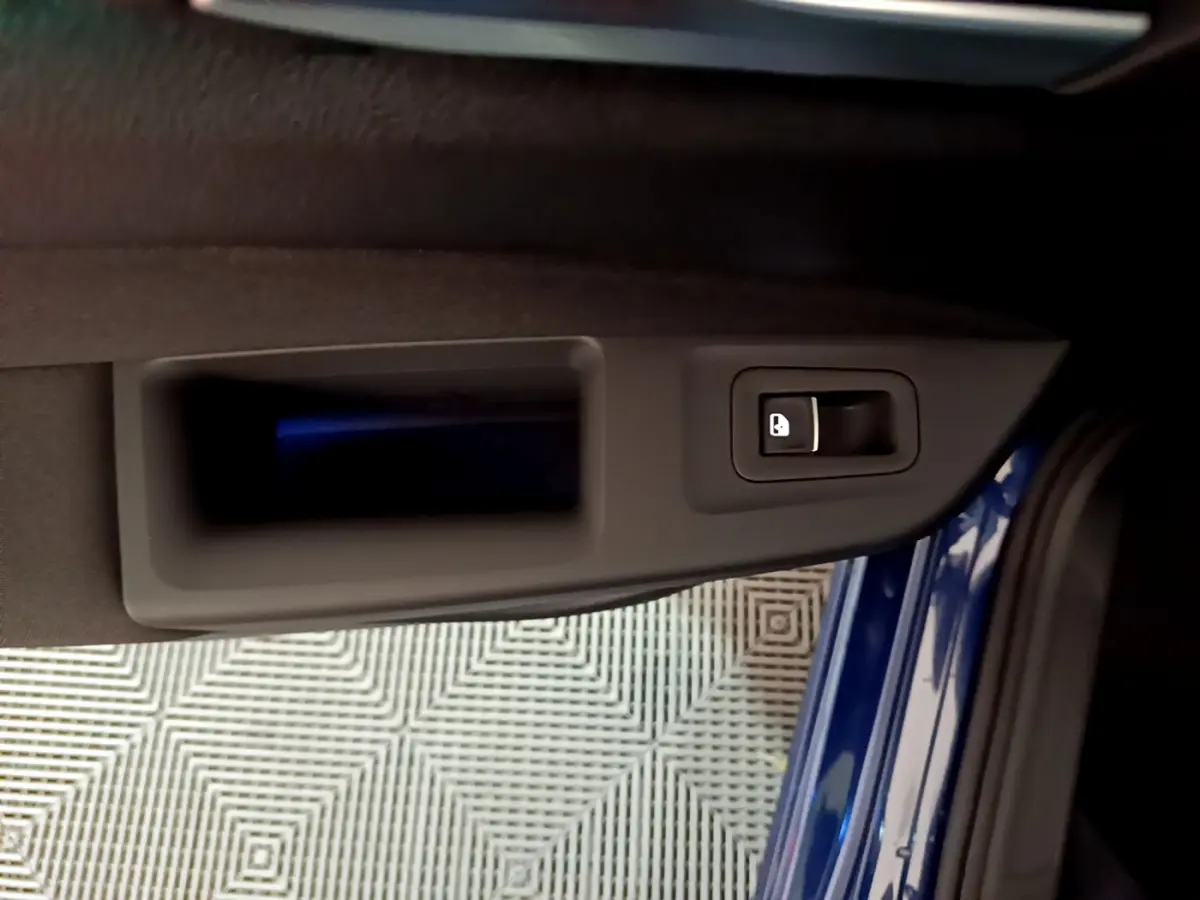 Poignée intérieure de porte côté gauche d'une Volkswagen Golf 1.0 TSI bleu 2022, avec bouton de verrouillage.