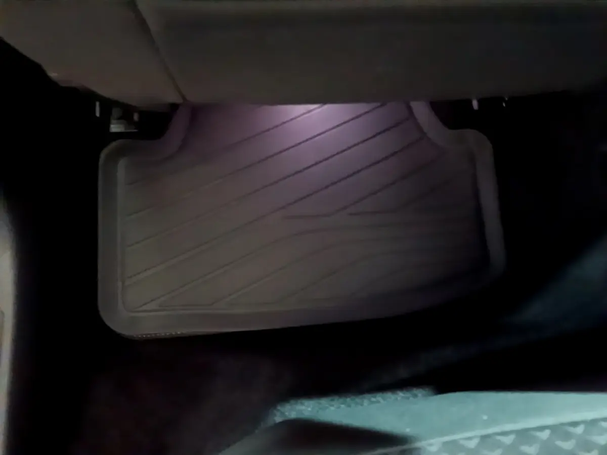 Tapis de sol noir côté conducteur de la Volkswagen Golf 1.0 TSI 2022, vue rapprochée sous le siège avant.